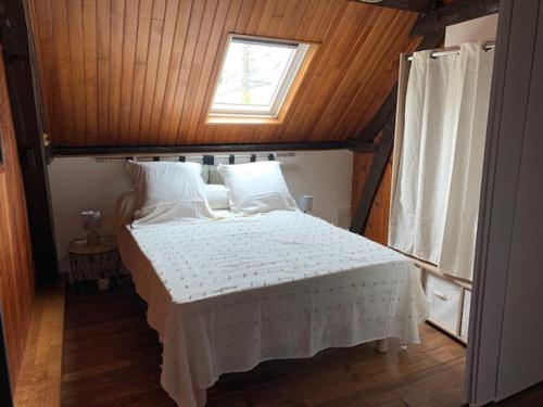 1 dormitorio con 1 cama grande y ventana en Le Relax, en Saint-Aignan