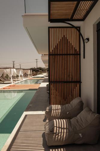 a person laying on a bed next to a swimming pool at Salt Boutique Hotel in Palouki