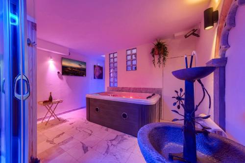 a bathroom with a tub in a room with purple lighting at Il Giardino Fiorentino - Luxury Apartment & Spa in Florence