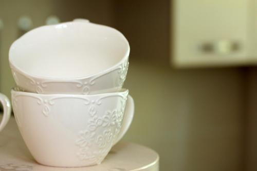 a stack of white cups sitting on top of a table at Apartment Danes 35 in Klaipėda