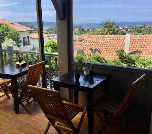 two tables and chairs on a balcony with a view at Casa Baia Hendaye in Hendaye