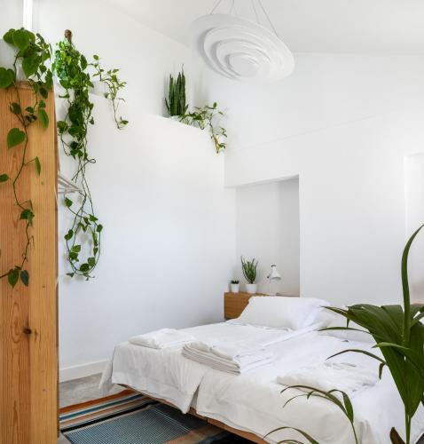 a bedroom with a bed with plants on the wall at OUTPOST - Ocean Casitas in Azenhas do Mar