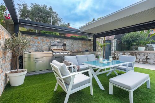 a patio with a table and chairs and a grill at Deluxe VILLA GRAZIELLA 200 M FROM THE BEACH in Èze