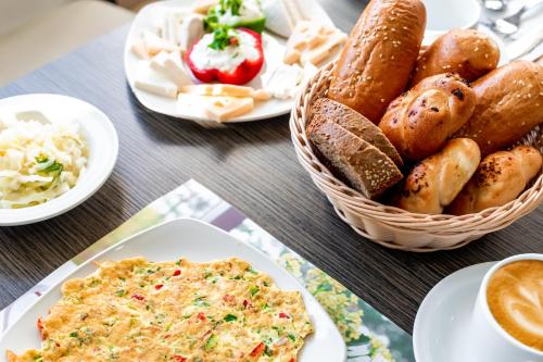 a table with plates of food and a basket of bread at Emily's Hotel in Tiberias