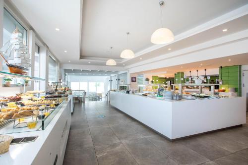a large kitchen with a counter in a restaurant at Lindos White Hotel & Suites in Líndos