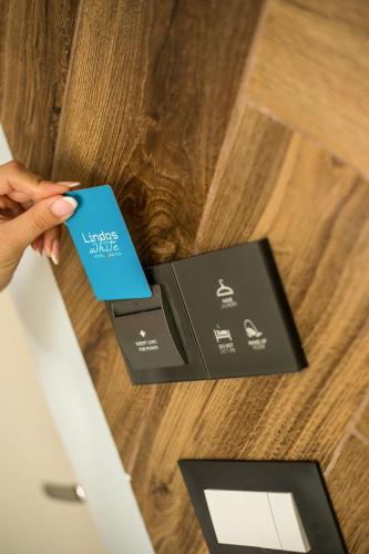a person holding a credit card next to a door at Lindos White Hotel & Suites in Líndos