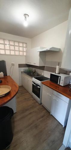 - une cuisine avec des appareils blancs et un comptoir en bois dans l'établissement Beau T2 en centre ville avec place de parking auto vélo, à Blois