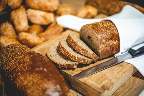 a loaf of bread on a cutting board with a knife at Emily's Hotel in Tiberias
