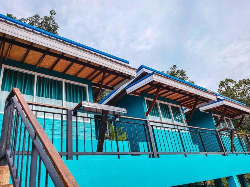 a blue house with a railing and a balcony at Ban Tidlay - SHA in Ko Yao Noi