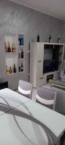 een woonkamer met een tafel en stoelen en een televisie bij Apartman LJILJANA BELA CRKVA in Bela Crkva
