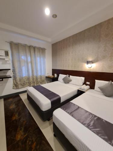una camera d'albergo con due letti e una cucina di My Stay Hotel a Butuan