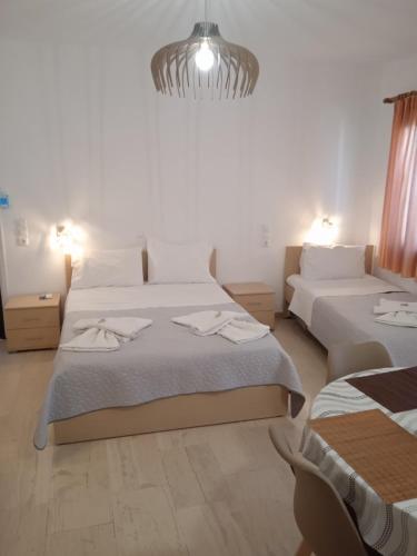 a bedroom with two beds and a chandelier at Αrgo Studios in Pythagoreio