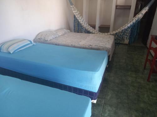 two beds in a room with a swing at Paracuru HolaOnda WaveHostel in Paracuru