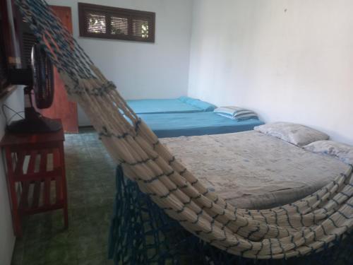a room with two beds and a rope bed at Paracuru HolaOnda WaveHostel in Paracuru