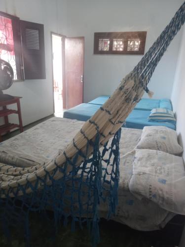 a hammock bed in a room with two beds at Paracuru HolaOnda WaveHostel in Paracuru