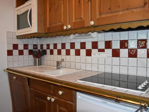 un comptoir de cuisine avec un évier et un micro-ondes dans l'établissement Charmant appart 3 pièces avec parking, près des pistes - FR-1-464-15, à Pralognan-la-Vanoise