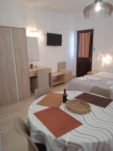 a room with two beds and a table with a bottle on it at Αrgo Studios in Pythagoreio