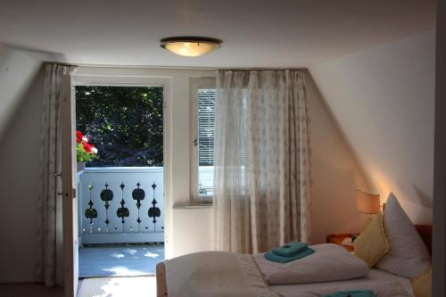 a bedroom with a bed in front of a window at Romantic-Pension Albrecht - Villa next to UNESCO World Heritage - since 1901 in Hohenschwangau