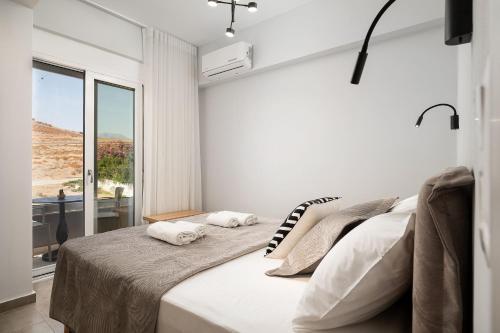 a bedroom with a large bed with a window at Gifel Apartments and Luxurious Suites in Kalamaki Heraklion