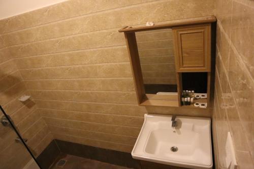 a bathroom with a sink and a mirror at Royal Destiny Resort in Malaiyāndipattanam