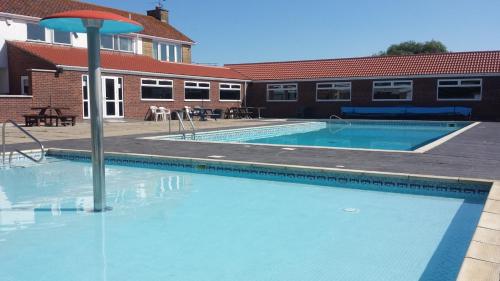 a large swimming pool in front of a building at Castaway Retreats 3 E65 in Lincolnshire