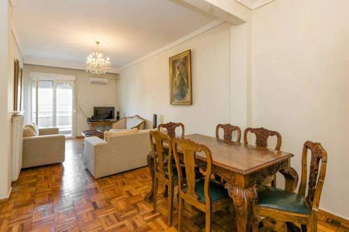salon z drewnianym stołem i krzesłami w obiekcie Κεντρικό κλασικό διαμέρισμα 2 δωματίων w Salonikach