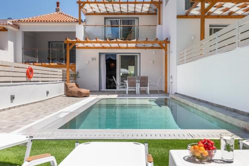 a villa with a swimming pool and a house at AGNONTAS LUXURY VILLAS in Agnontas
