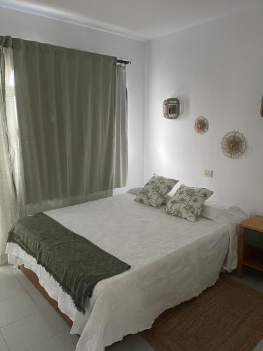 a bedroom with a large bed with a window at Villa Natura Maspalomas Complejo Playmar in Maspalomas