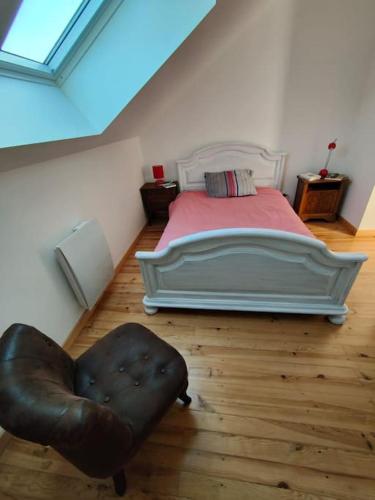 - une chambre avec un lit et un fauteuil en cuir dans l'établissement Appartement 4/6 pers, jardin, 6 km de la plage, à Saint-Julien-en-Born
