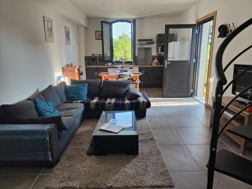a living room with a couch and a table at Appartement 4/6 pers, jardin, 6 km de la plage in Saint-Julien-en-Born
