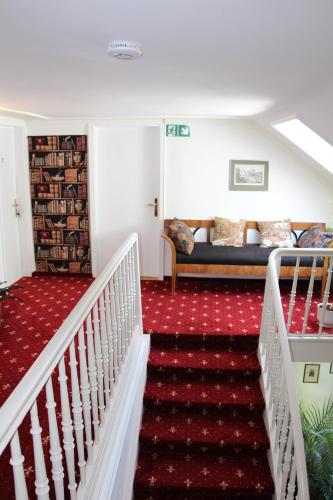 a room with a staircase with a couch and a bed at Romantic-Pension Albrecht - Villa next to UNESCO World Heritage - since 1901 in Hohenschwangau
