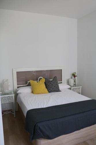a bedroom with a large bed with yellow pillows at casa dellamore in Cártama