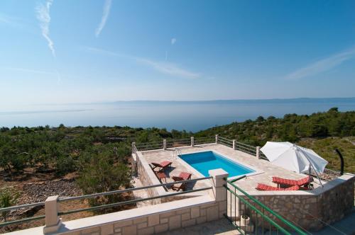 a villa with a swimming pool and the ocean at kamena kuća kanava in Selca