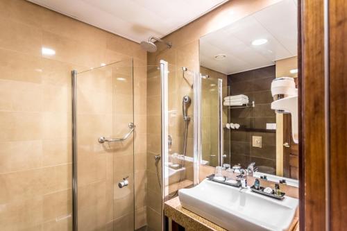 a bathroom with a sink and a shower at Emily's Hotel in Tiberias