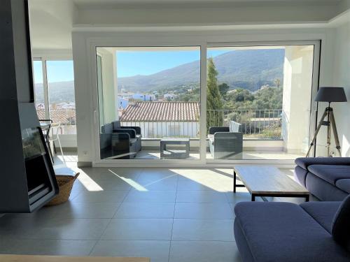 a living room with a couch and a large window at HERETAT - Casa con garaje a 5 minutos del centro in Cadaqués
