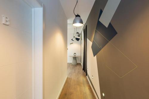 un couloir menant à une chambre avec une table et une lampe dans l'établissement Ronda9 central suites, à Madrid