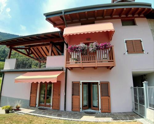 a house with a balcony with flowers on it at Casa Vacanze Cillà in Comano Terme
