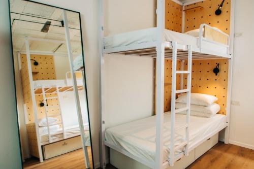 Łóżko piętrowe w pokoju z lustrem w obiekcie Gia Dormitory w Tel Awiwie