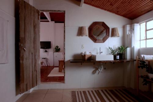 a bathroom with a mirror and a sink in a room at Hospedagem Fazenda Nova América in Brotas