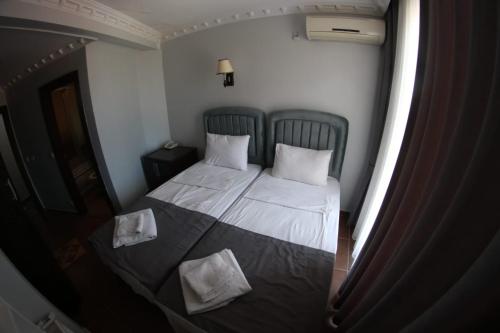 a small bedroom with a bed with two pillows at Ares Hotel in Istanbul