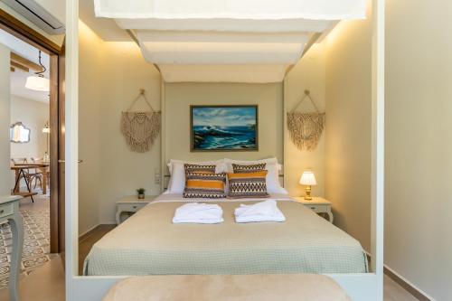 a bedroom with a large bed with two pillows at AGNONTAS LUXURY VILLAS in Agnontas