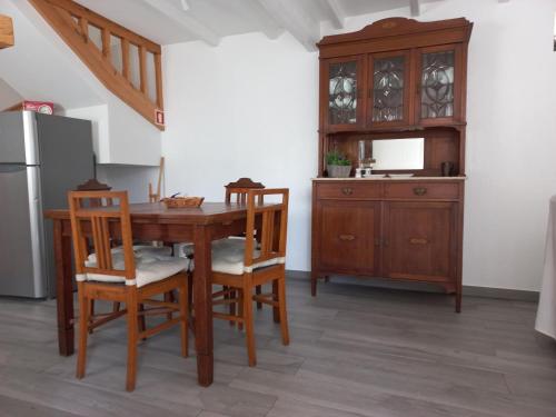 a kitchen with a wooden table and chairs and a refrigerator at Casa Manel d'Anita in Alge