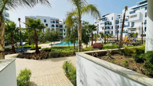 a view of a resort with a pool and palm trees at Luxury Apartment with Pool in Martil