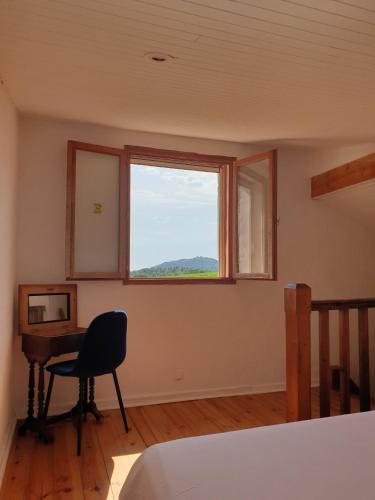 - une chambre avec un bureau, une fenêtre et une chaise dans l'établissement Gite Les Robiniers, à Beaumont-de-Pertuis