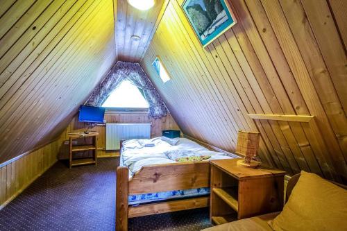 a small bedroom with a bed in a attic at Aparthotel Pod Nosalem in Zakopane