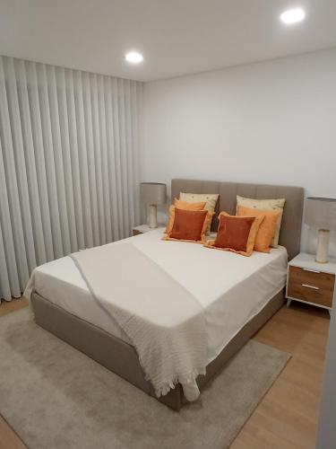 a bedroom with a large bed with orange pillows at Casa de Ponte in Ponte de Lima