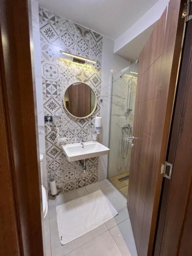 a bathroom with a sink and a shower with a mirror at Mia's Favorite Hotel in Mavrovo