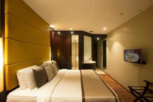 a bedroom with a large bed with a yellow wall at Sea Shell Coral Cove in Port Blair