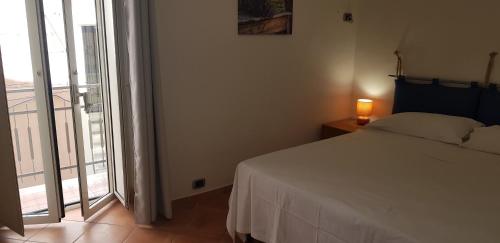 una camera con un letto bianco e una grande finestra di CASTELLO a 2 minuti a piedi dal centro e 10 minuti a piedi dalla spiaggia di Vindicio a Formia
