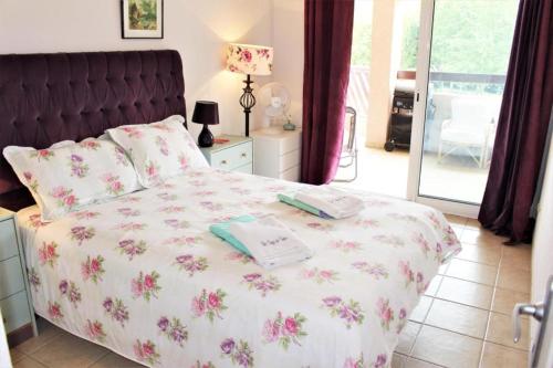 - une chambre avec un lit orné de fleurs roses dans l'établissement Amiraute Apartment J9, à Saint Cyprien Plage